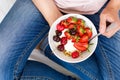 Healthy eating concept. Women`s hands holding bowl with muesli, yogurt, strawberry and cherry. Top view. Lifestyle Royalty Free Stock Photo