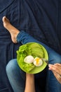 Healthy eating concept. Women`s hands holding plate with lettuce, avocado slices and poached eggs Royalty Free Stock Photo