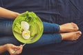 Healthy eating concept. Women`s hands holding plate with lettuce, avocado slices and poached eggs Royalty Free Stock Photo