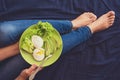 Healthy eating concept. Women`s hands holding plate with lettuce, avocado slices and poached eggs Royalty Free Stock Photo