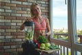 Close up of young woman with blender and green vegetables making detox shake or smoothie at home Royalty Free Stock Photo