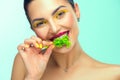 Healthy eating, diet. Beautiful healthy girl eating raw vegan food and smiling. Beauty young fashion woman eats green fresh lettuc Royalty Free Stock Photo