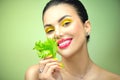 Healthy eating, diet. Beautiful healthy girl eating raw vegan food and smiling. Beauty young fashion woman eats green fresh lettuc Royalty Free Stock Photo