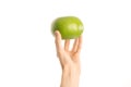 Healthy eating and diet Topic: Human hand holding a green sweetie isolated on a white background in the studio, first-person view Royalty Free Stock Photo