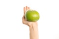 Healthy eating and diet Topic: Human hand holding a green sweetie isolated on a white background in the studio, first-person view Royalty Free Stock Photo