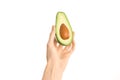 Healthy eating and diet Topic: Human hand holding a half avocado isolated on a white background in the studio, first-person view Royalty Free Stock Photo