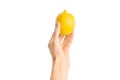 Healthy eating and diet Topic: Human hand holding yellow lemon isolated on a white background in the studio, first-person view Royalty Free Stock Photo