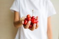 Healthy eating, dieting, vegetarian food and people concept- closeup of woman hand holding fresh berries cherry wearing white Royalty Free Stock Photo
