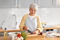 happy woman chopping red onion on kitchen