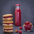 Oat cookies with raspberry, soft cheese, honey and raw raspberry and red juice on the background of black slate , close up Royalty Free Stock Photo