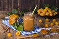 Mug glass of juice smoothie shake from yellow plum, jam and ripe yellow plum, on a vintage wooden table. Bio healthy food and drin Royalty Free Stock Photo