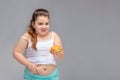 Healthy eating, glutton, bad nutritional habits, overeating, fast food, overweight. baby girl with excess weight keeps the