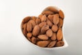 Healthy eating habits and heart healthy foods concept with a heart shaped bowl filled with almonds isolated on white background Royalty Free Stock Photo