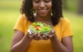 Healthy eating. Happy black girl holding bowl of fresh vegetable salad outdoors, selective focus Royalty Free Stock Photo