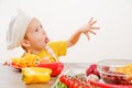 Healthy eating. Happy child prepares and eats vegetables in kitchen Royalty Free Stock Photo