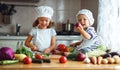 Healthy eating. Happy children prepares vegetable salad in kitc Royalty Free Stock Photo