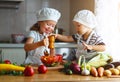 Healthy eating. Happy children prepares vegetable salad in kitc Royalty Free Stock Photo