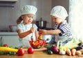 Healthy eating. Happy children prepares vegetable salad in kitc Royalty Free Stock Photo