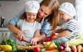 Healthy eating. Happy family mother and children prepares vegetable salad Royalty Free Stock Photo