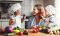 Healthy eating. Happy family mother and children prepares vegetable salad Royalty Free Stock Photo