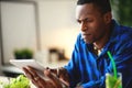 Healthy eating. happy young black man eating salad with phone and tablet pc in morning Royalty Free Stock Photo