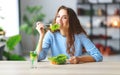 Healthy eating. happy young girl eating salad in morning in kitchen Royalty Free Stock Photo