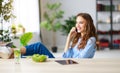 Healthy eating. happy young girl eating salad with tablet pc in morning in kitchen Royalty Free Stock Photo