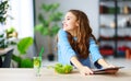 Healthy eating. happy young girl eating salad with tablet pc in morning in kitchen Royalty Free Stock Photo