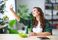 Healthy eating. happy young girl eating salad with tablet pc in morning in kitchen Royalty Free Stock Photo