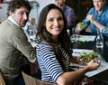 Healthy eating keeps the office up and running. Portrait of a young office worker eating lunch with coworkers at a