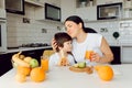 Healthy Eating. mom with baby eating fruits in the kitchen Royalty Free Stock Photo