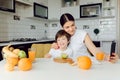 Healthy Eating. mom with baby eating fruits in the kitchen Royalty Free Stock Photo