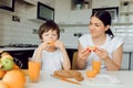 Healthy Eating. mom with baby eating fruits in the kitchen