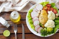 Healthy eating plate of grilled chicken breast and vegetable salad over rustic wooden table. Ketogenic and Paleolithic Diet