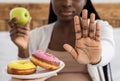 Healthy Eating During Pregnancy. Black Pregnant Lady Refusing Unhealthy Donuts, Choosing Apple Royalty Free Stock Photo