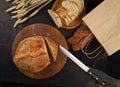 hopped grain bread put on kitchen wood plate with knife for cut. Fresh bread on table close-up. Fresh bread on the Royalty Free Stock Photo