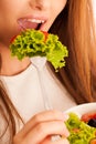 Healthy eating - woman eats a bowl of greek salad isolated over Royalty Free Stock Photo