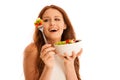 Healthy eating - woman eats a bowl of greek salad isolated over Royalty Free Stock Photo