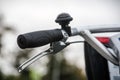 Bicycle handlebar, brake lever and bel close-up over blurred avenue Royalty Free Stock Photo