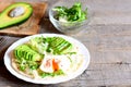 Healthy egg breakfast. Poached egg, avocado slices, cabbage, lettuce mix, tortilla, sauce and spices Royalty Free Stock Photo