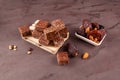 Healthy energy candies in the form of cubes on a pallet. Nearby are the ingredients dates, dried apricots, prunes and nuts.