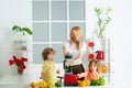 Healthy family food. Mother daughter and little son preparing healthy smoothie in the modern kitchen. Royalty Free Stock Photo