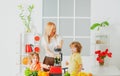 Healthy family food. Mother daughter and little son preparing healthy smoothie in the modern kitchen. Royalty Free Stock Photo