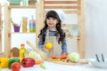 Healthy Family. Kid girl cooking and cutting vegetables for healthy care on kitchen. Daughter making cookie, so happy. Royalty Free Stock Photo