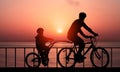 Healthy Family Lifestyle Concept. Father and His Son Cycling Together in a family Bicycle Against a Beautiful Sunrise Sea Royalty Free Stock Photo