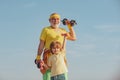 Healthy family lifestyle. Grandfather and little grandson practice dumbbells exercises outdoors. Motivation and sport