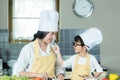 Healthy Family. Mother and kid boy cooking and cutting salad fresh vegetables for diet in kitchen.  Smiling son  help mom making c Royalty Free Stock Photo