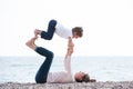 Healthy family playful pretty mother and child making exercises on autumn beach