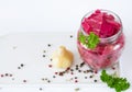 Healthy fermented canned cabbage sauerkraut with beetroot and herbs in a glass jar top view