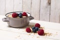 Oatmeal in cute little gray pot and berries in rural style setting